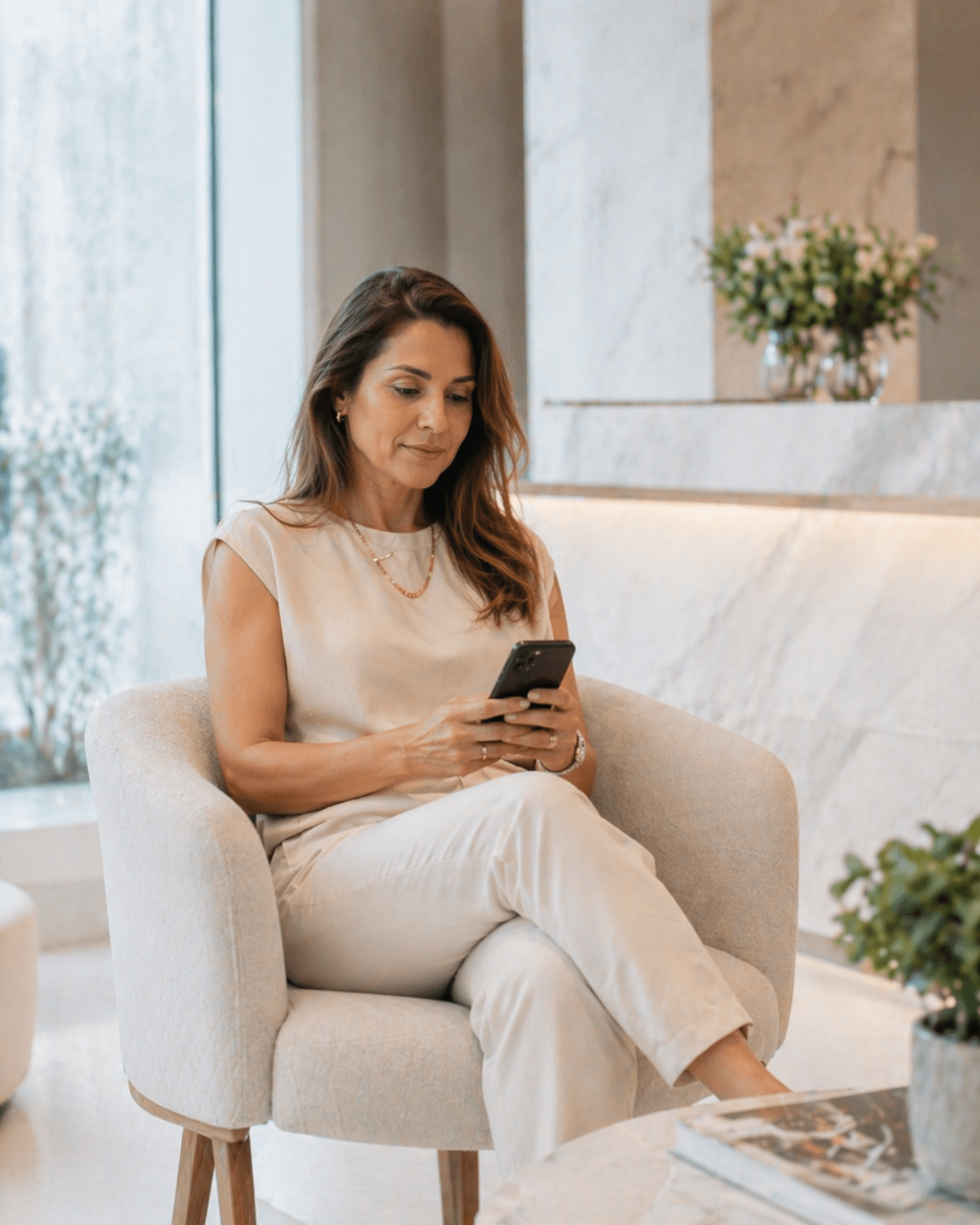Paciente em lounge de clínica premium acessando o portal com autonomia e tranquilidade.